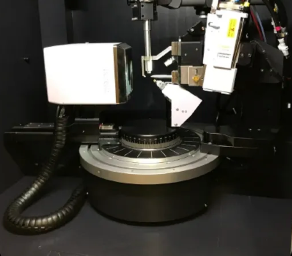 Close-up of a mechanical device with a camera and arm on a dark background